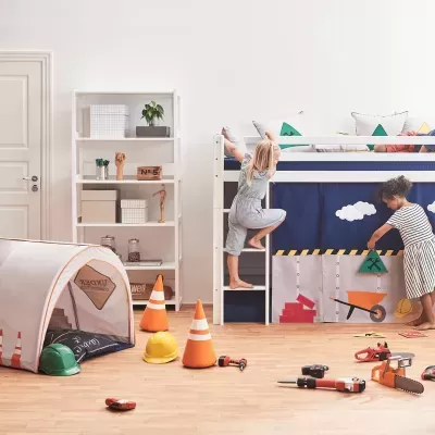 Quarto infantil com beliche, cortina de carrinho, tenda, cones, capacetes e brinquedos de ferramentas