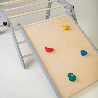 Estrutura de escalada infantil em madeira com agarradores coloridos