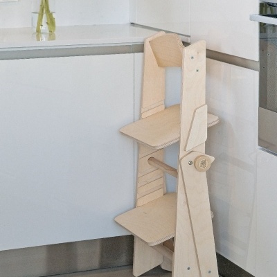 Cadeira ergonómica ajustável em madeira clara numa cozinha branca