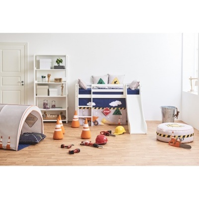 Quarto infantil com cama branca com escorrega, tenda de tecido e cones de sinalização.