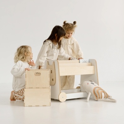 Crianças brincando com móveis infantis de madeira clara e caixas