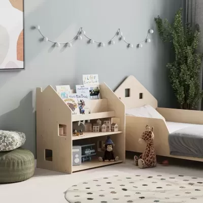 Armário infantil em madeira clara com livros e brinquedos, cama infantil e peluche de girafa num quarto de criança.