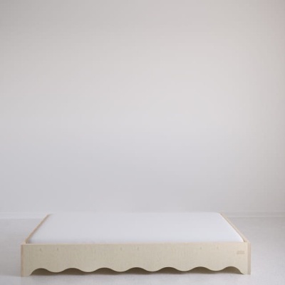 Cama baixa com estrutura de madeira clara, colchão branco, fundo branco