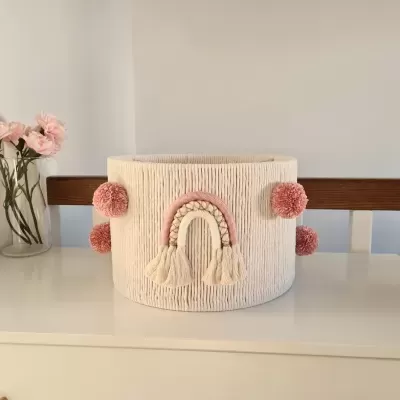 Cesto tecido creme com pompons rosas e arco-íris decorativo
