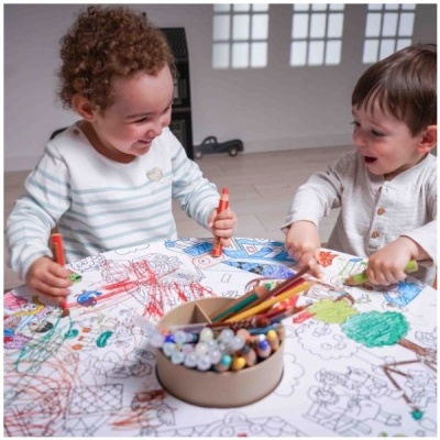 Crianças a pintar mesa com marcadores e lápis de cor