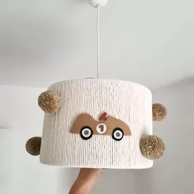 Candeeiro de teto bege com decoração de carro castanho e pompons castanhos