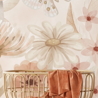 Papel de parede floral em tons pastel com manta laranja sobre móvel creme