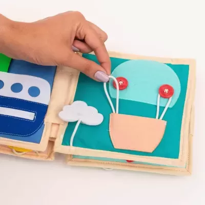 Livro infantil de tecido colorido com botões e cordões manipuláveis