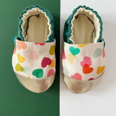 Sapatos de bebé brancos com corações coloridos e solas douradas