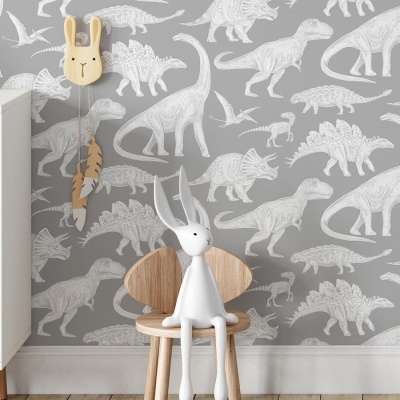 Interior de quarto com papel de parede cinza de dinossauros brancos e cadeira de madeira com coelho decorativo branco