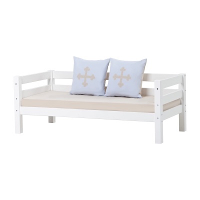 Sofá cama branco com almofadas azuis claras e decoração de cruz