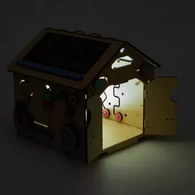 Casa de brinquedo de madeira iluminada, com porta aberta e acessórios coloridos