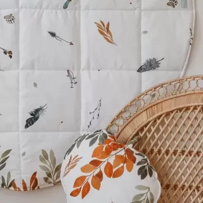 Tapete e almofada com estampado de folhas em cadeira de vime