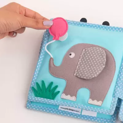 Livro de tecido azul com elefante cinzento e bola rosa