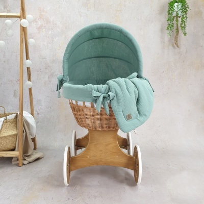 Carrinho de bebé em vime e tecido verde água com manta no interior