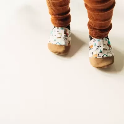 Sapatinhos de bebé com padrão colorido de obras