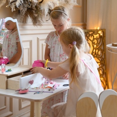 Móvel infantil de madeira com espelho e duas meninas a brincar