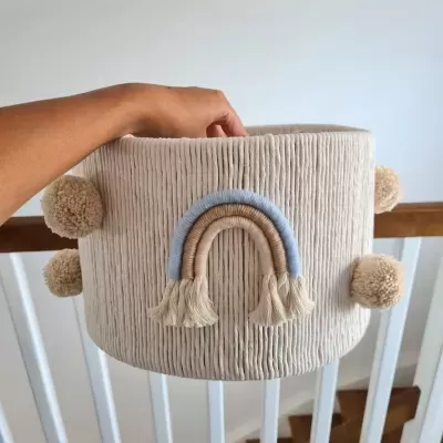 Cesto de tecido cinzento claro com arco-íris decorativo e pompons