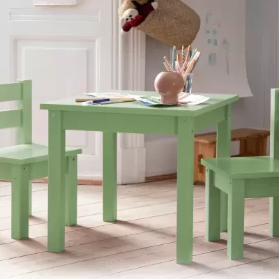 Mesa e duas cadeiras infantis verdes com lápis e papéis sobre a mesa, em ambiente interior com chão de madeira.