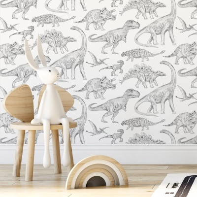 quarto infantil com papel de parede de dinossauros a lápis cinzentos, cadeira de madeira clara e boneco branco sentado