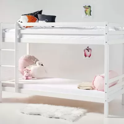 Beliche branco de madeira com colchões brancos e decoração com almofadas e peluches.