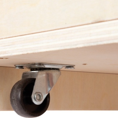 Roda preta com suporte metálico montada em móvel de madeira clara