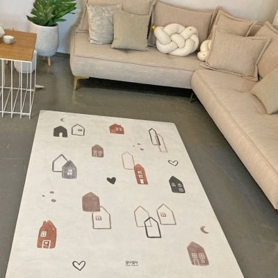 Tapete branco com desenhos de casas coloridas junto a sofá bege e mesa lateral de madeira