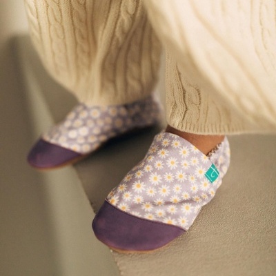 Pantufas floridas lilás com biqueira roxa e calças creme de malha grossa