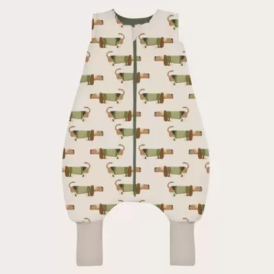 Macacão de bebé com padrão de cães castanhos com camisola verde em fundo creme