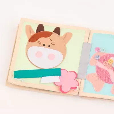 Livro infantil de tecido com vaca e porco coloridos com figuras removíveis