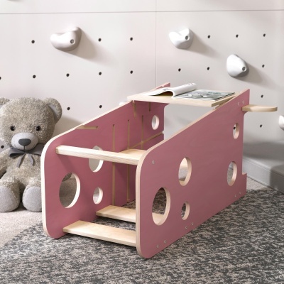 Estrutura de madeira rosa infantil com buracos circulares e tapete cinzento
