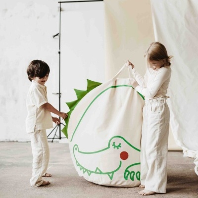 Dois miúdos a segurar saco de tecido com desenho de crocodilo