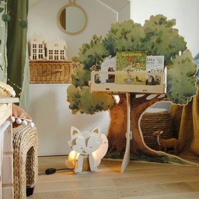 Estante de livros infantil em forma de árvore, luminária de raposa, caixotes de vime e espelho redondo de madeira