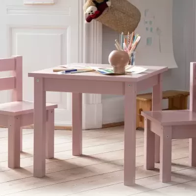 Conjunto infantil de mesa e cadeiras rosa de madeira numa sala clara