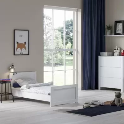 Quarto infantil com cama branca, roupa de cama branca, tapete azul, e decoração com raposa e brinquedos.