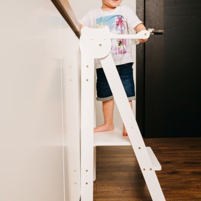 Criança em escada de madeira branca num ambiente interior