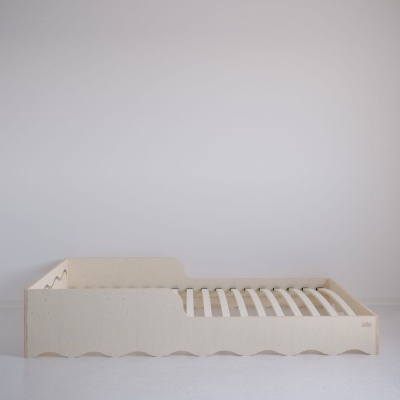 Cama de criança em madeira clara com ripas e laterais onduladas