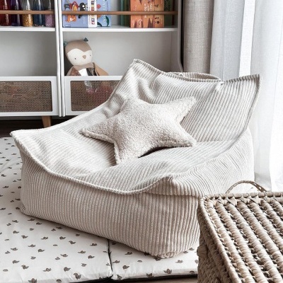 Poltrona bege claro de tecido riscado com almofada estrela em pelúcia