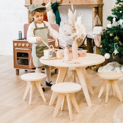 Mesa e bancos de madeira clara em ambiente infantil com decoração de Natal