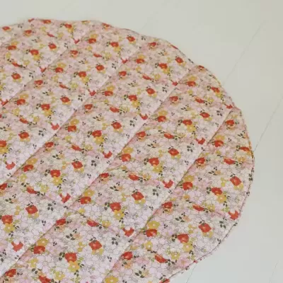 Tapete redondo floral almofadado sobre chão claro