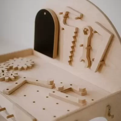 Banco de trabalho infantil em madeira clara com ferramentas de madeira