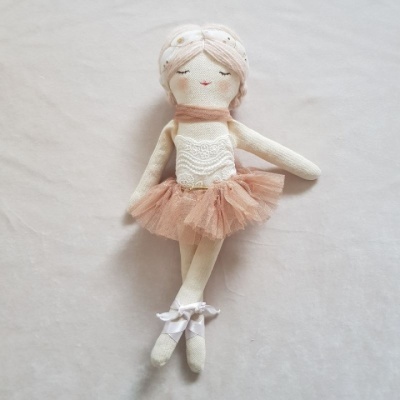 Boneca de tecido vestindo tutu cor de salmão e sapatilhas de ballet brancas