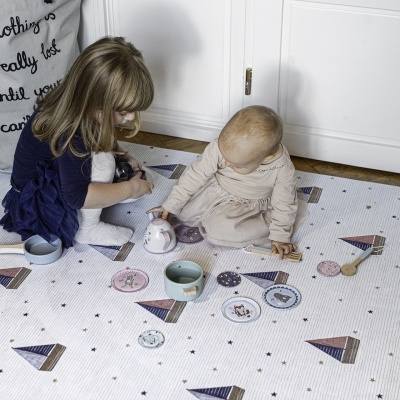 Tapete infantil branco com padrão de balões coloridos, crianças brincando sentadas no tapete