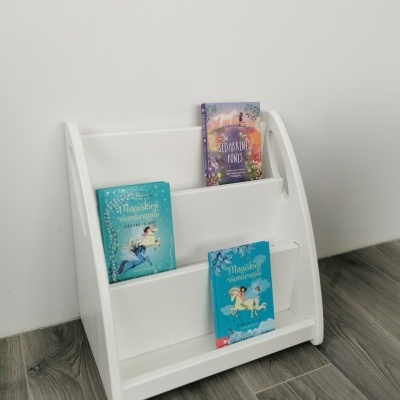 Estante branca de madeira para livros com três níveis e três livros coloridos