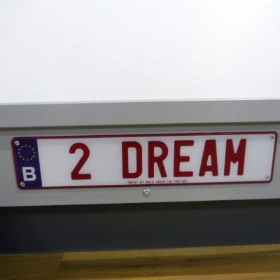 Placa de matrícula branca com letras vermelhas 2 DREAM e sinalização europeia azul