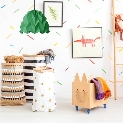 Quarto infantil com cestos de tecido, carrinho de madeira e decoração de parede colorida