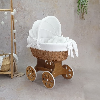 Carrinho de bebé em vime com forro branco e estrutura em madeira