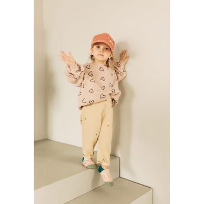 Criança com roupa casual colorida sentada numa escada cinzenta