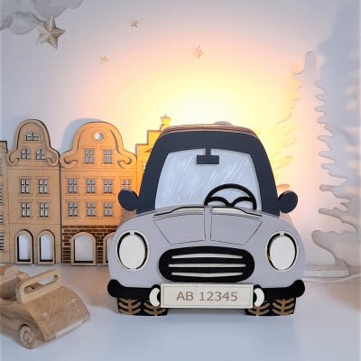 Iluminação decorativa em forma de carro cinzento, com madeira e elementos decorativos de casas e árvore
