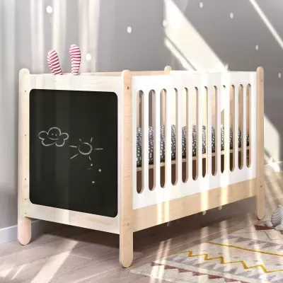 Berço de madeira clara com quadro negro e desenhos de sol e nuvem